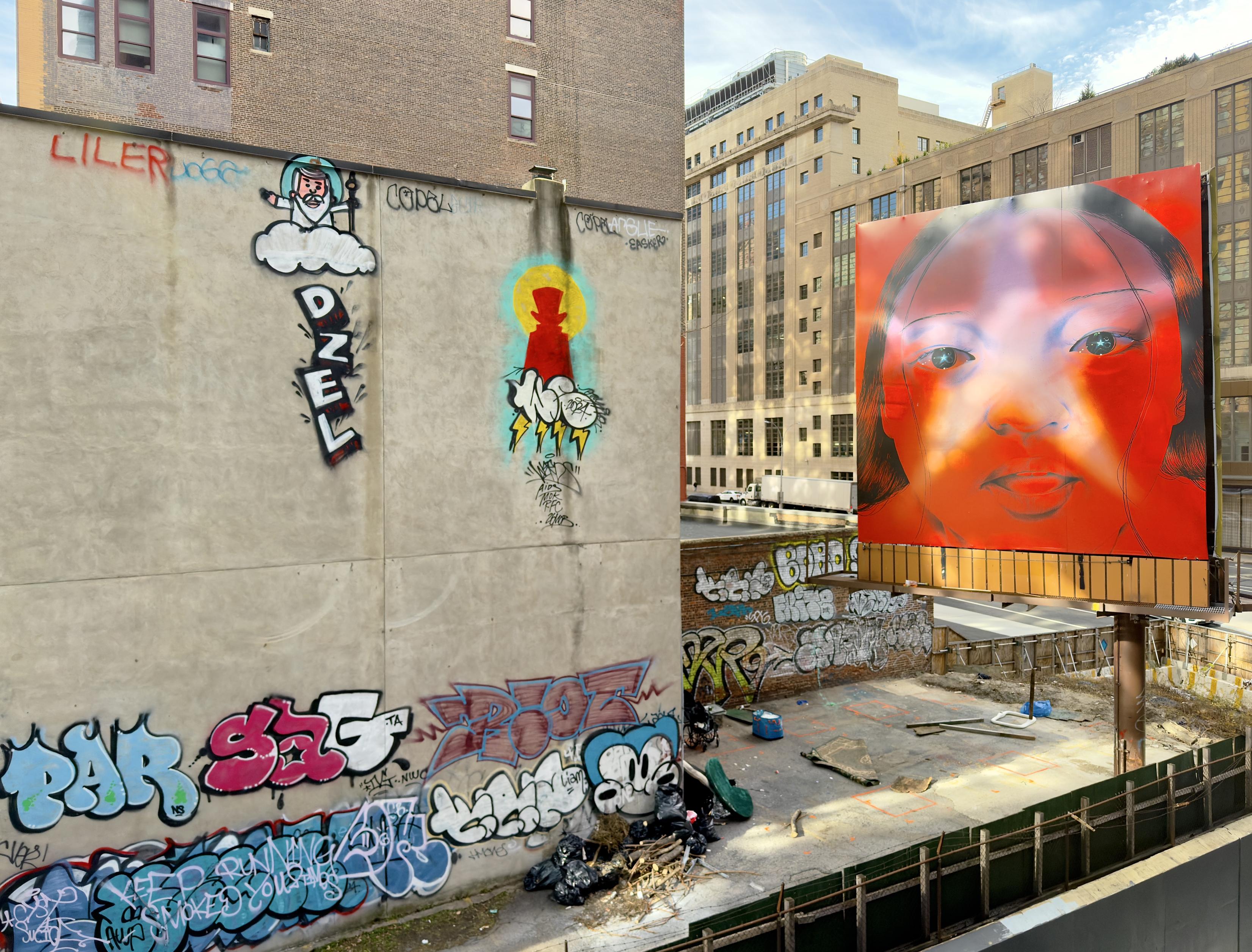 A color, medium-angle photograph captures the street art scene from the High Line in Manhattan. The focal point on the left is a large, unadorned concrete wall covered in several distinct styles of graffiti. Prominently featured are two figurative pieces: a cartoon-style figure of an old man with a beard sitting on a cloud (God) and below it, a silhouette of a top-hatted figure in red and black, both surrounded by bright yellow and blue halo effects and lightning bolts. The lower part of the wall and surrounding brick structures are heavily tagged with bubble letters and complex throw-ups in various colors like red, blue, and black. Debris and scattered construction materials are visible in the fenced-off lot below. Dominating the right side of the image is a massive, brightly colored billboard-style artwork featuring a close-up, stylized portrait of a woman's face, primarily rendered in a vibrant red and orange palette with a translucent star shape quality over her eyes. This large, contemporary piece stands elevated on poles above the street. The afternoon sky is partly cloudy, with strong natural light illuminating the scene.