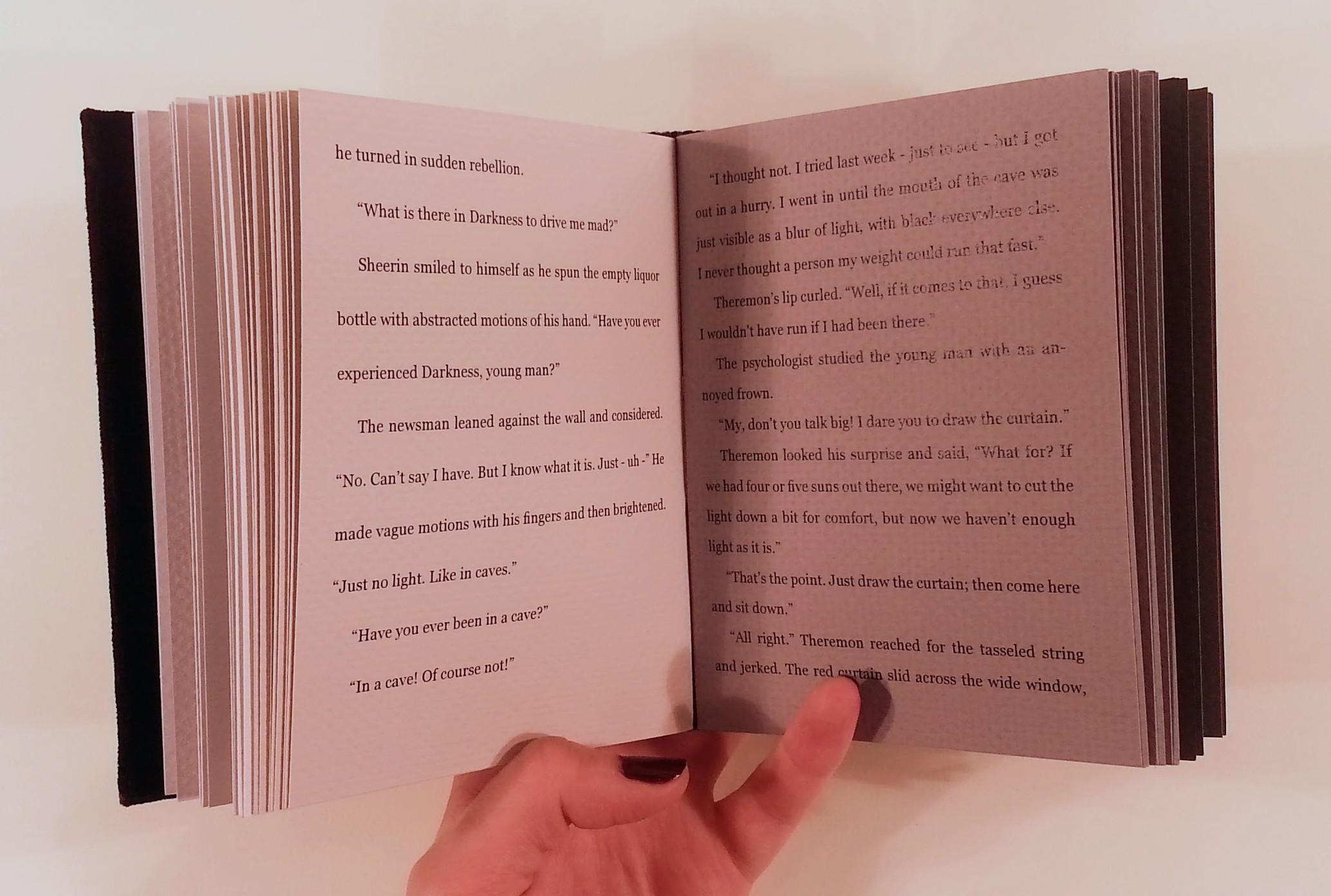 A spread of a bound version of Nightfall. The left page is light gray with large spacing between the lines of text. The right page is medium gray with smaller spacing between the lines of text.