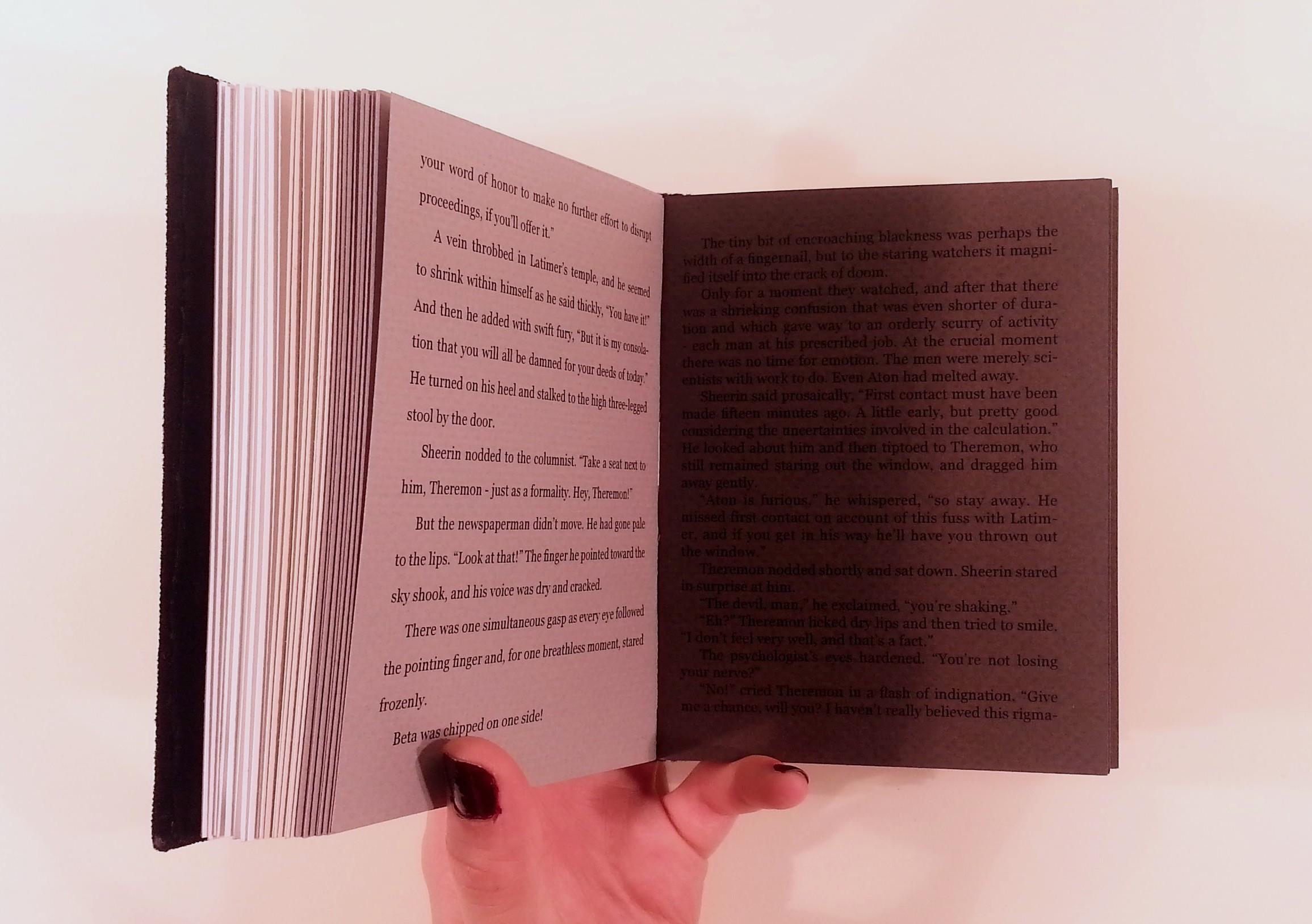 A spread of a bound version of Nightfall. The left page is medium gray with small spacing between the lines of text. The right page is very dark gray with very small spacing between the lines of text.