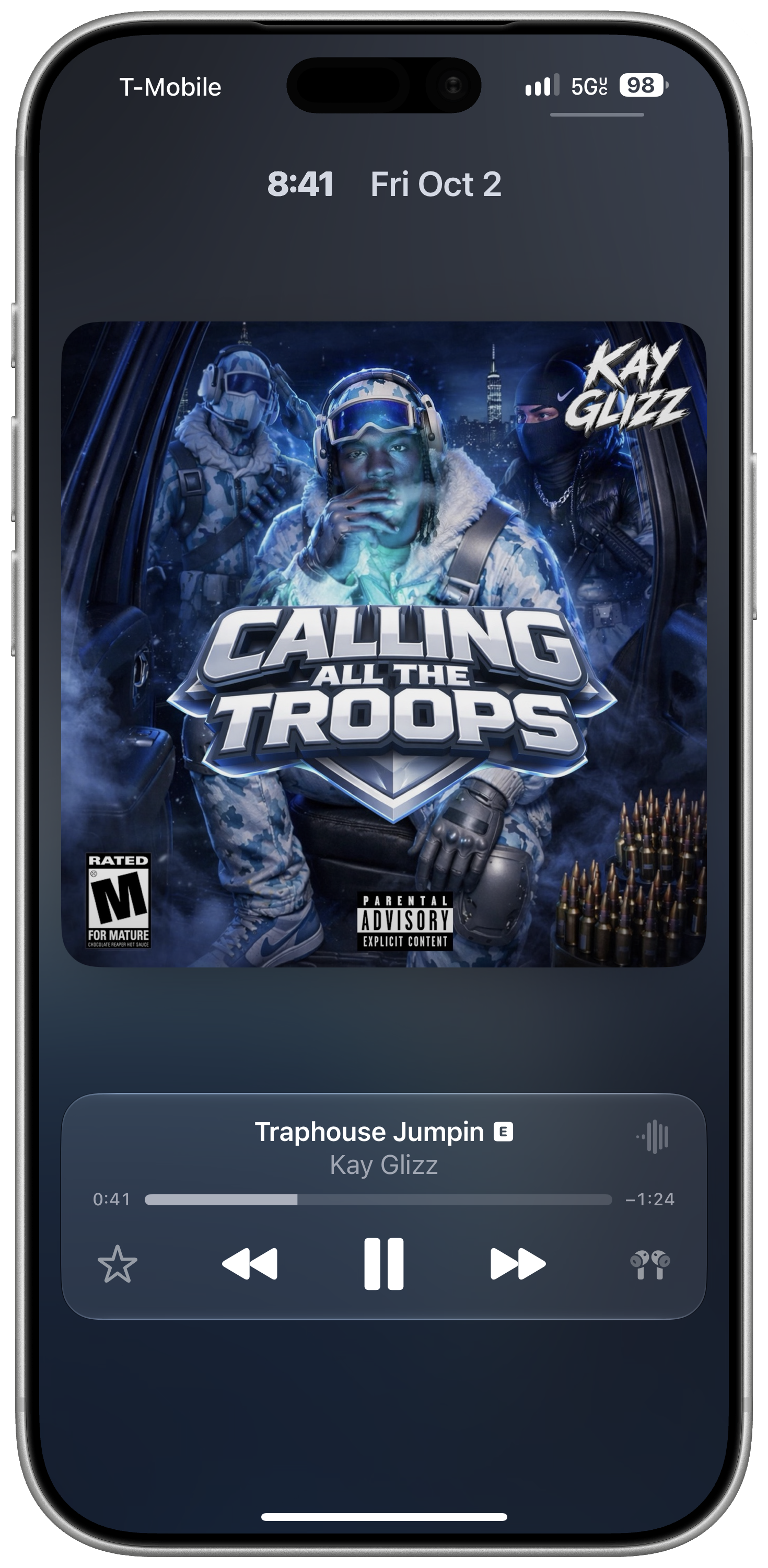 A framed screenshot of the iOS 27 lock screen showing the enlarged album artwork view with the player at the bottom, and a thin bar above the artwork for the time and date.